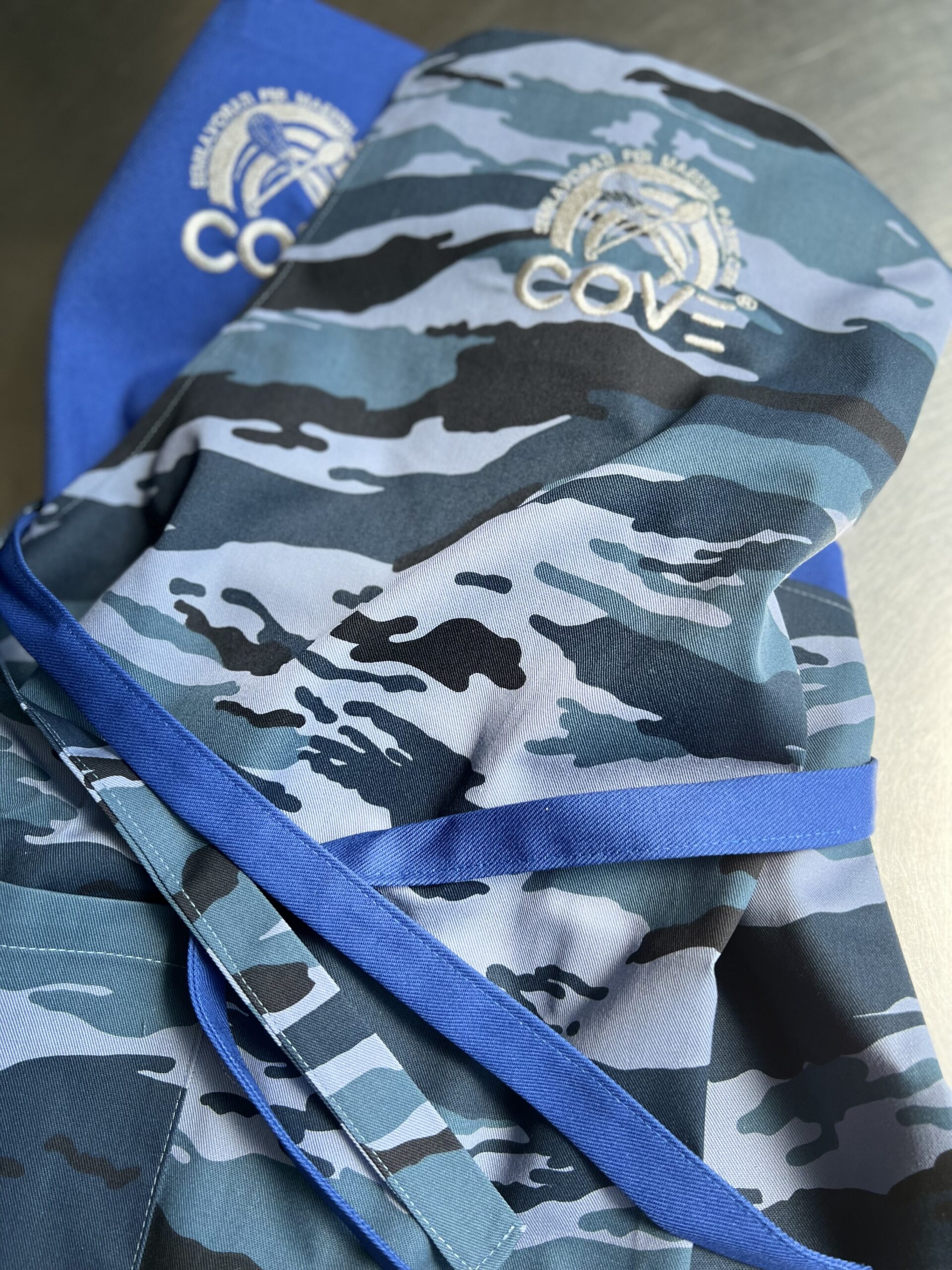 GREMBIULE CAMOUFLAGE CON PETTORINA E RICAMO LOGO COVE IN ARGENTO